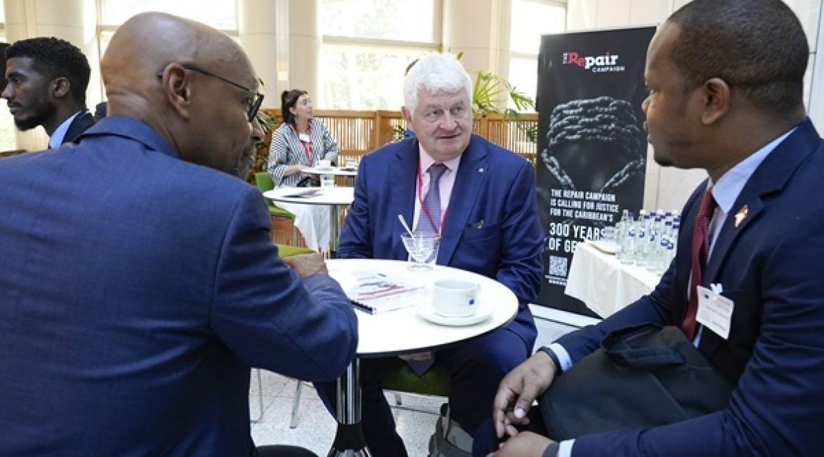 Denis O’Brien in gesprek met Professor Jean Marie Théodat (l) en Simba St. Bernard van de Ambassade van Grenada, België