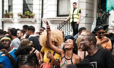 Zwarte feestende menigte met een witte toezichthouder op de achtergrond.